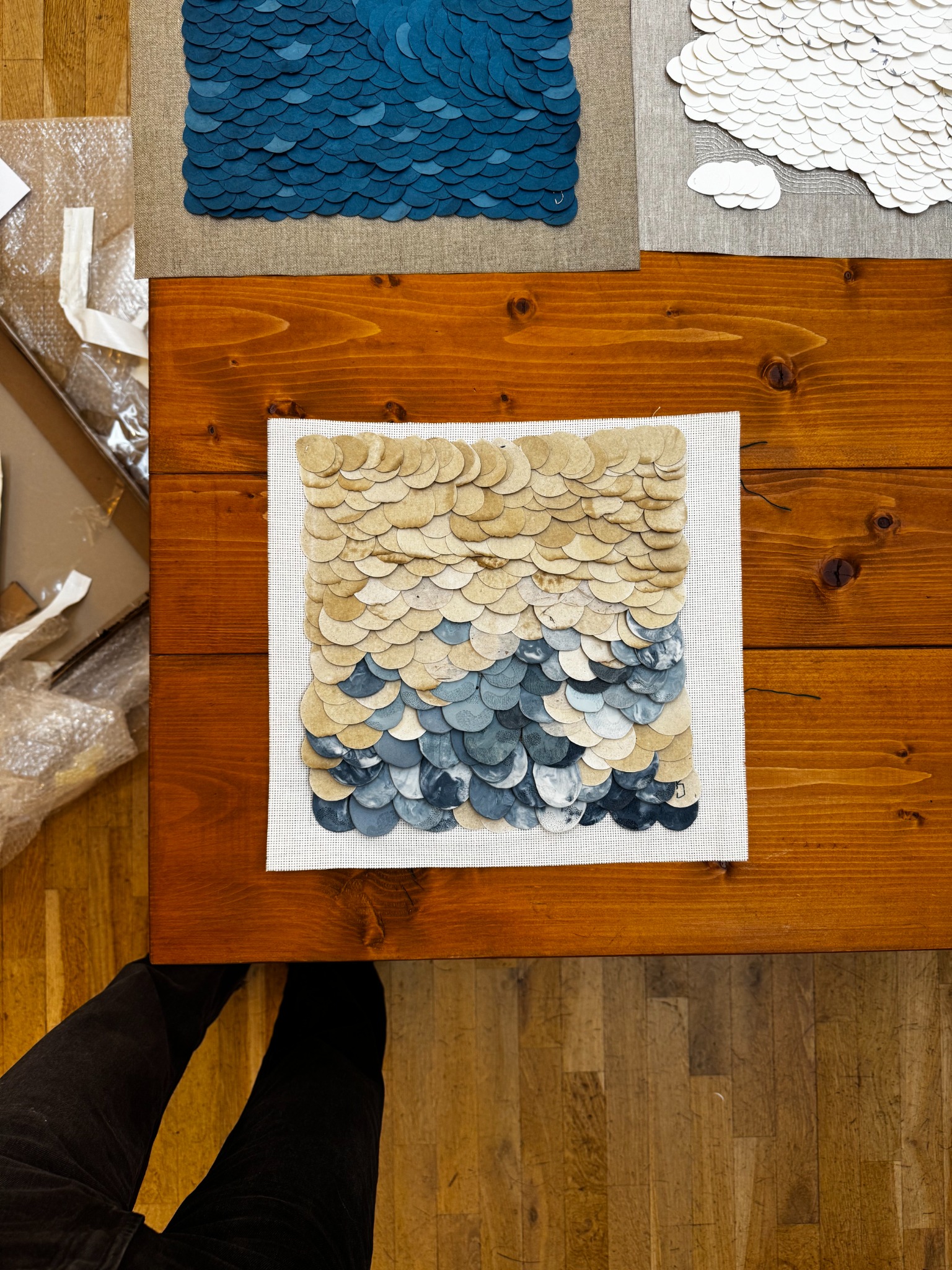 Close-up of layered mixed-media artwork on a studio table