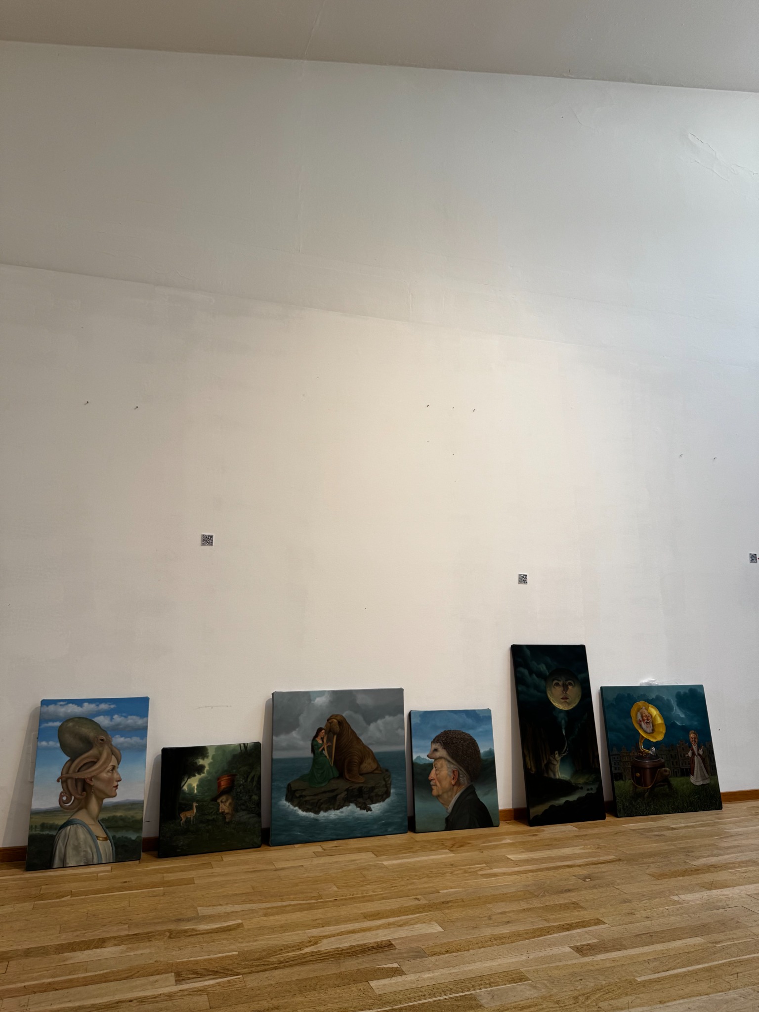 Exhibition installation in progress with artworks arranged along the wall