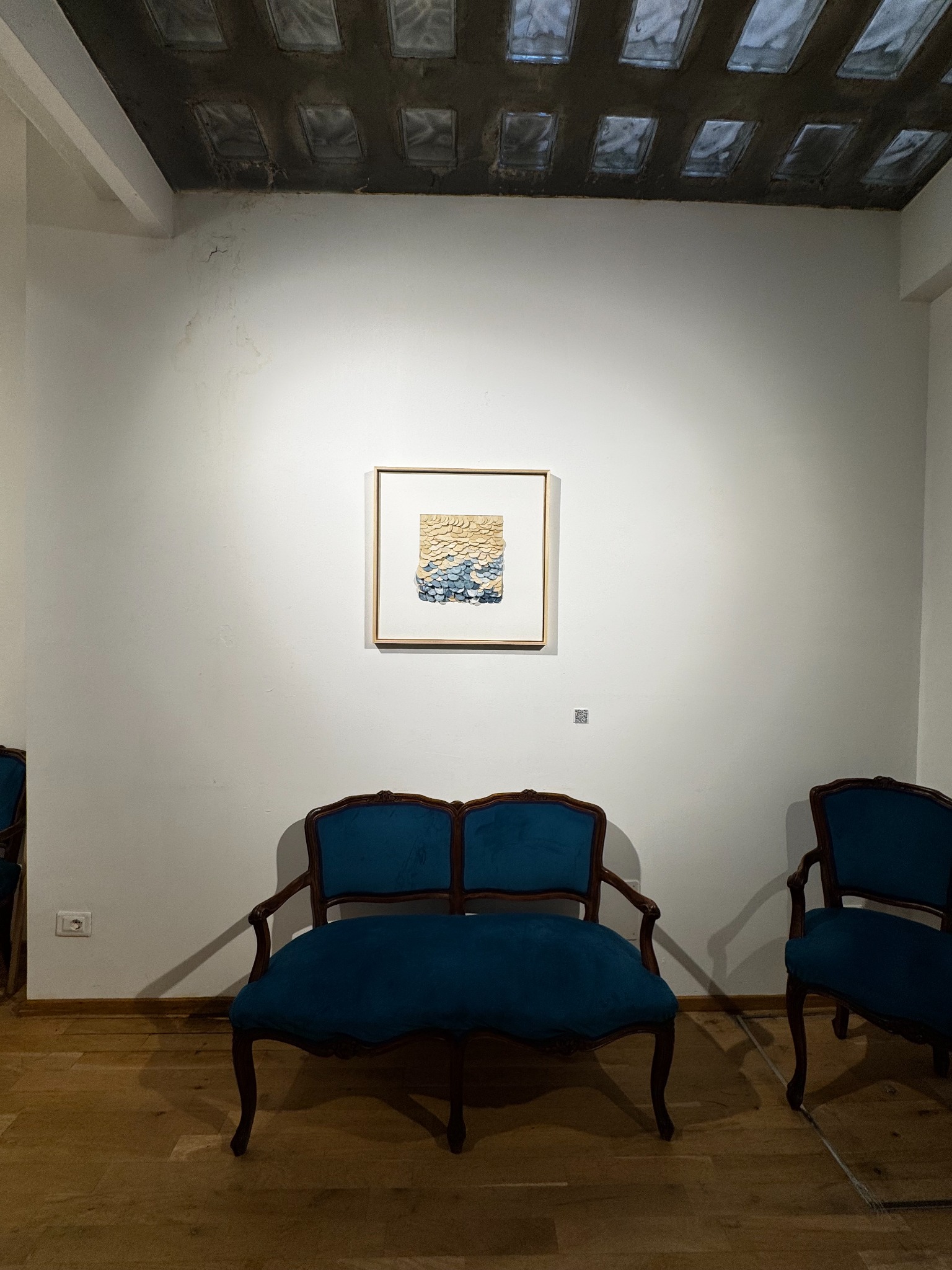 Installed Caroline Karenine artwork above a blue settee